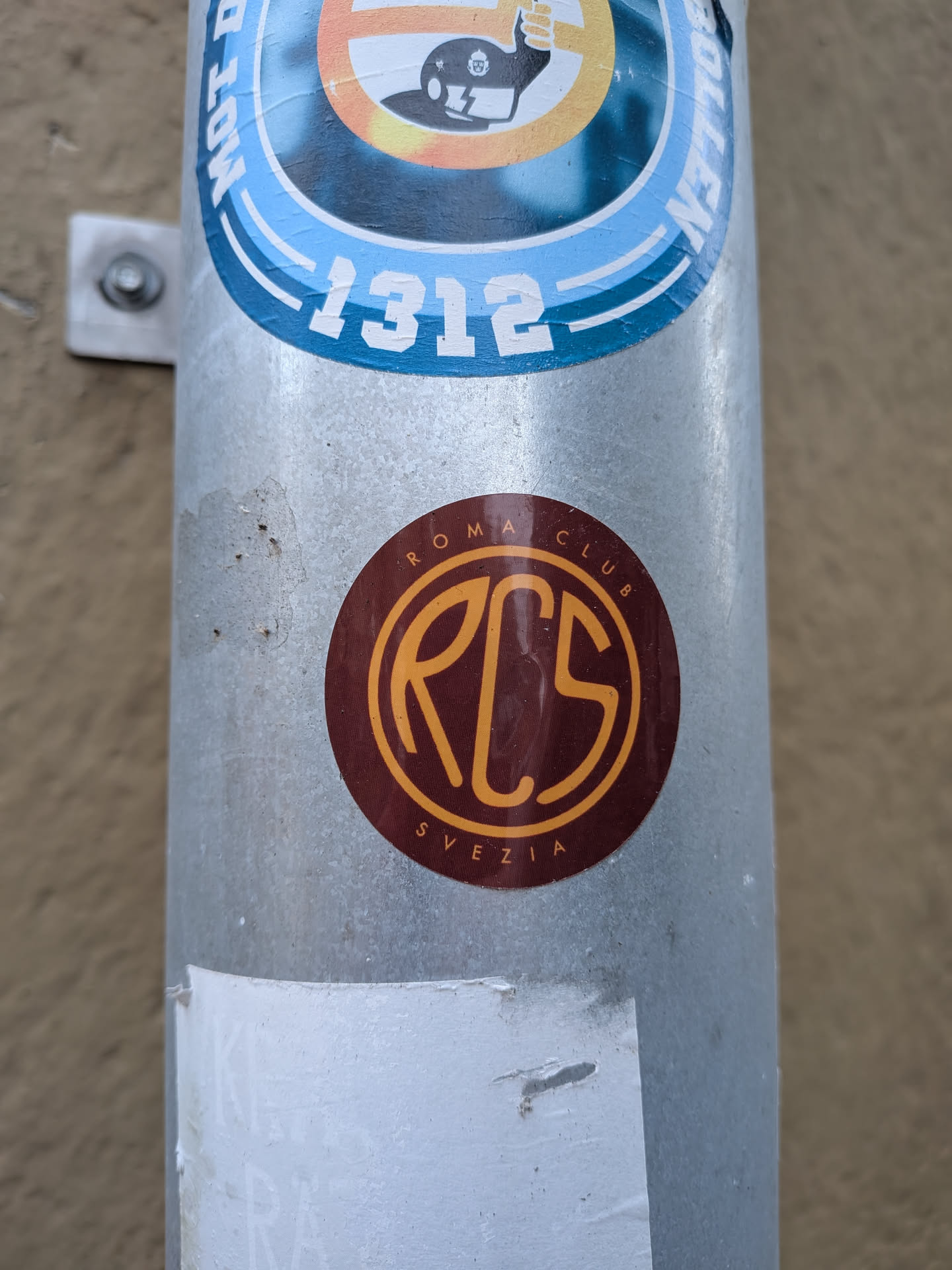 A round sticker featuring a deep maroon-red background. At the center is an intertwined, stylized monogram logo reading 'RCS' enclosed in a thin gold circle. Along the outer top rim, the text 'ROMA CLUB' is arched in gold capital letters, and 'SVEZIA' is curved along the bottom edge in the same color and typeface.
