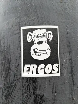 Black and white sticker featuring an angry monkey illustration with the word ERGOS written below it.