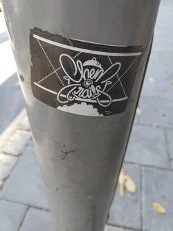 Black and white sticker with the words Chem Trails in a stylized font. The design includes an airplane-like shape and some other graphic elements. The sticker is slightly damaged.
