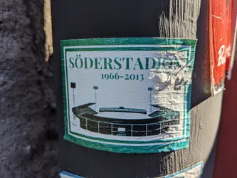 A sticker commemorating Söderstadion, a football stadium in Stockholm, Sweden, that was in use from 1966 to 2013. The sticker features a simple illustration of the stadium.