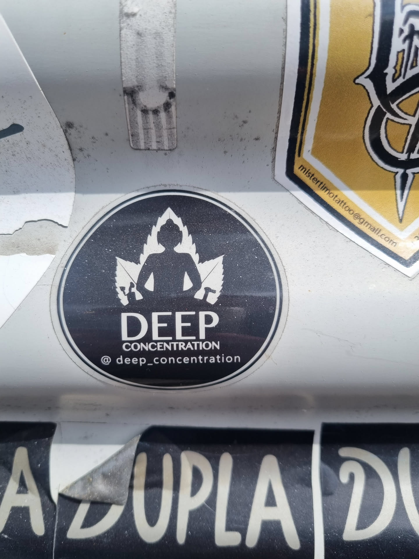 Black and white round sticker with a figure meditating in the middle of cannabis leaves. The text "DEEP CONCENTRATION" is written below the figure.  A social media handle is visible at the bottom.