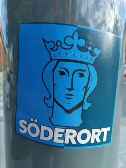 A sticker featuring a stylized illustration of a king's head wearing a crown, set against a blue and dark teal background. The word "Södermalm" is written at the bottom.