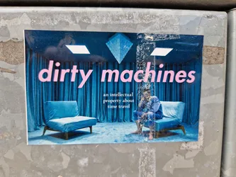 A sticker featuring the words "dirty machines" in pink lettering against a backdrop of a dark blue, almost teal, room with velvet curtains and two small blue lounge chairs.  A person is seated in one of the chairs. The phrase "an intellectual property about time travel" appears in smaller text below the title. The image style is reminiscent of 80s or 90s graphic design.