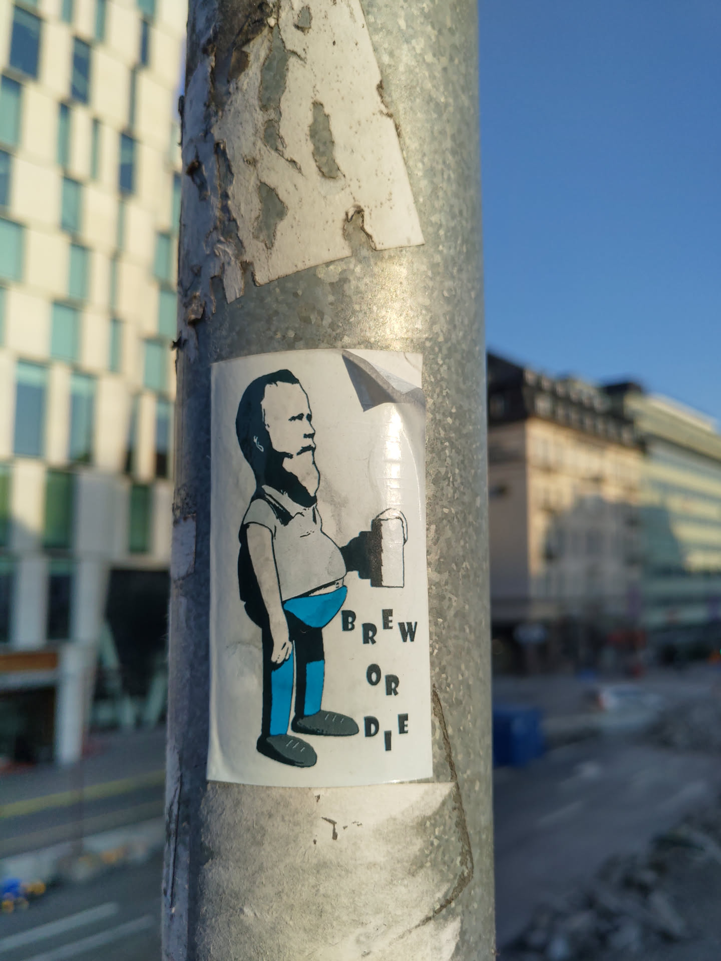 A sticker featuring a cartoon illustration of a man holding a beer mug. The text 'Brew or Die' is prominently displayed. The art style is simple and slightly humorous.