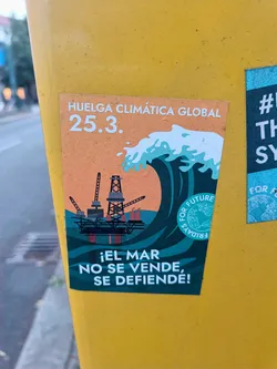 Sticker featuring a wave engulfing an oil rig, with the text 'Huelga Climática Global 25.3.' and '¡El mar no se vende, se defiende!' (The sea is not for sale, it is defended!).  The design promotes climate action and environmental protection.