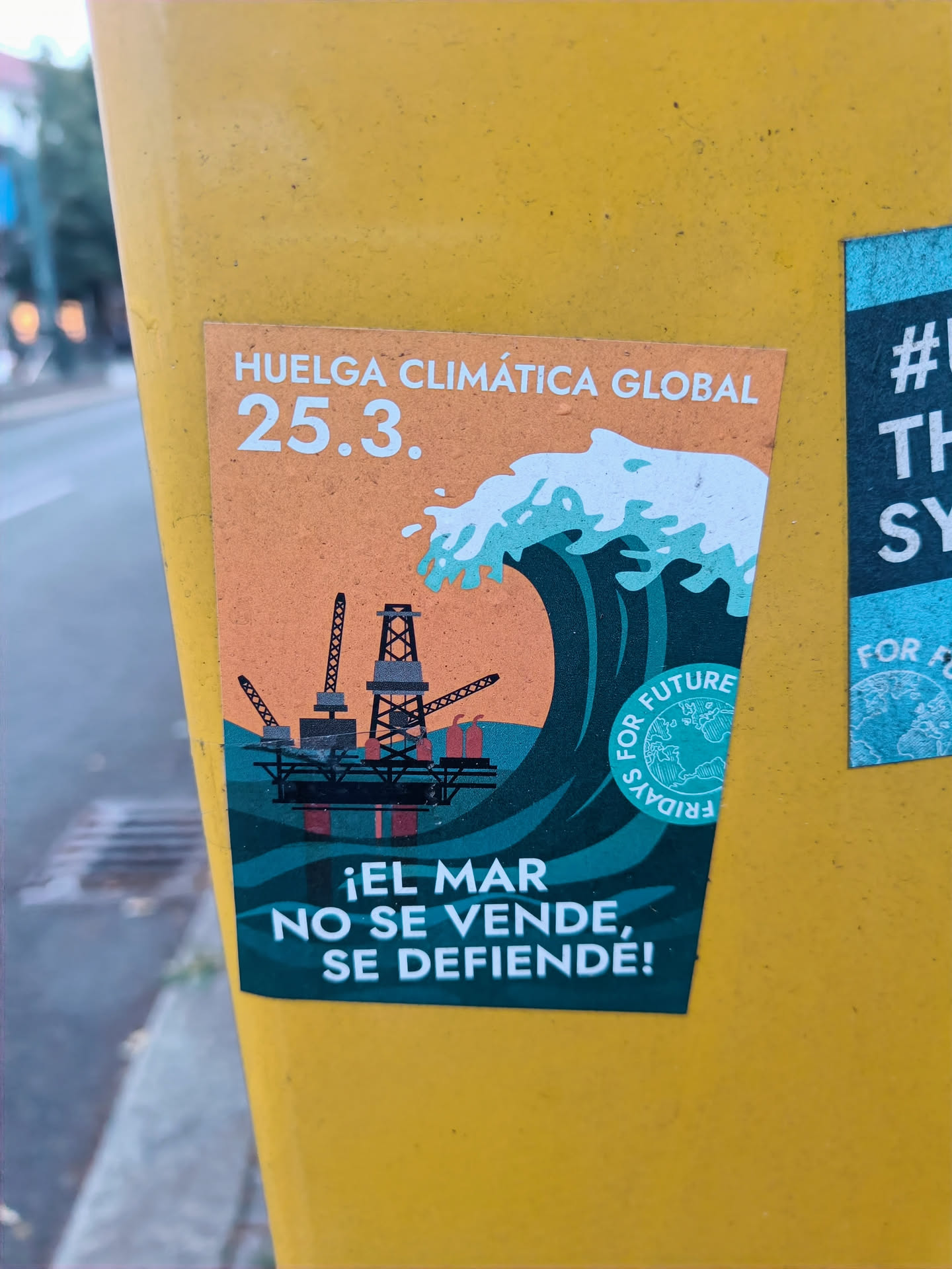 Sticker featuring a wave engulfing an oil rig, with the text 'Huelga Climática Global 25.3.' and '¡El mar no se vende, se defiende!' (The sea is not for sale, it is defended!).  The design promotes climate action and environmental protection.