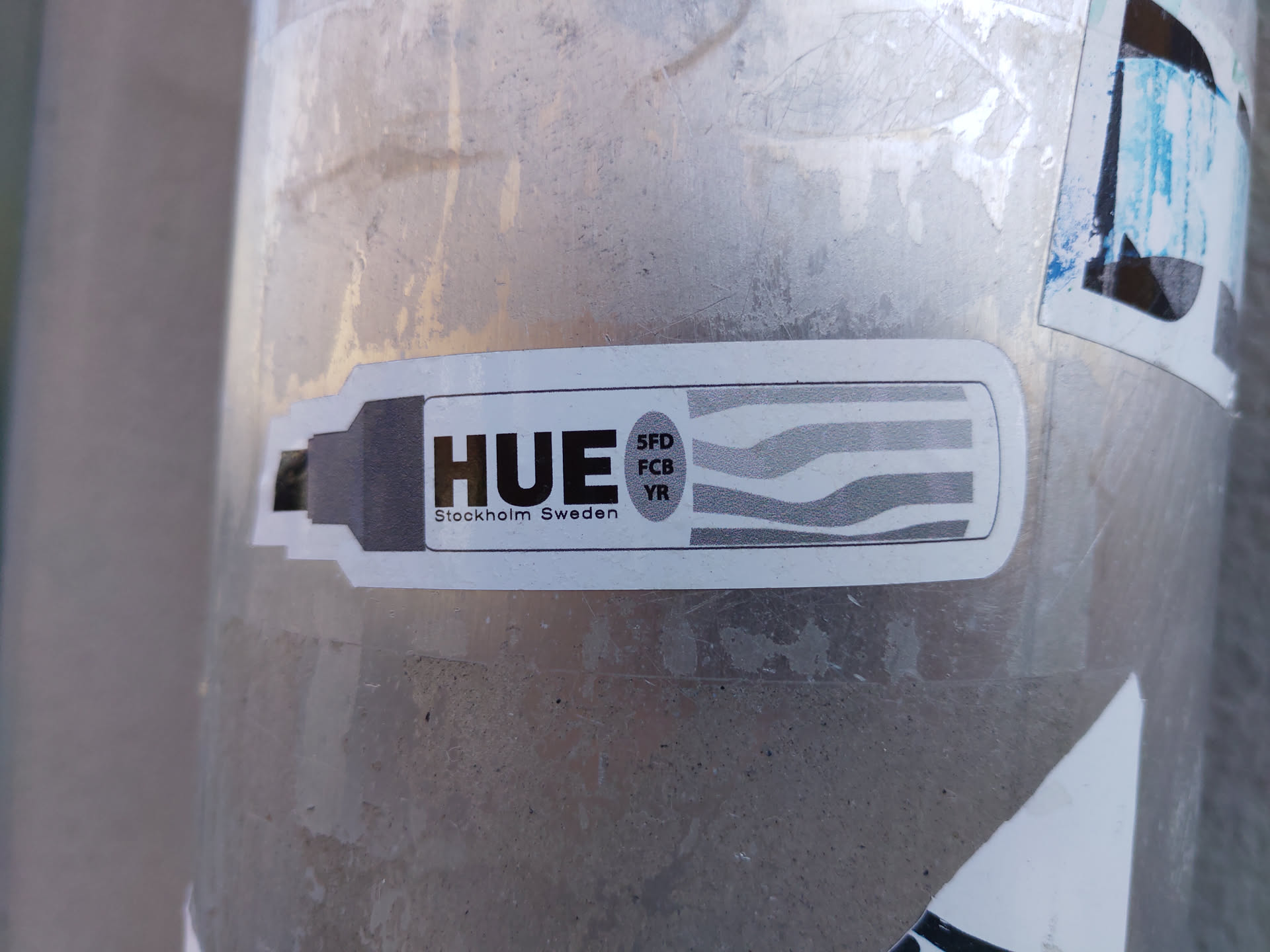 A sticker featuring the word HUE, along with the text "Stockholm Sweden" and a graphic design resembling color stripes.