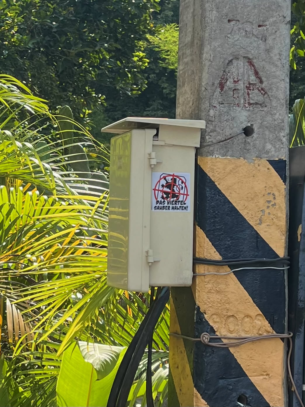 A rectangular sticker with a white background, featuring a stylized black lion within a circular cage or enclosure. A prominent red circle with a diagonal line (the universal 'no' or 'prohibited' symbol) is overlaid on the lion and cage. Below the graphic, two lines of black text are present in a sans-serif font. The overall design conveys a clear public service message.