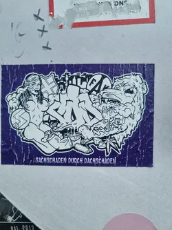 A purple sticker with a graphic design featuring a woman, a lion, graffiti, and other elements. The text at the bottom reads "Sachschaden durch Dachschaden", which translates from German to "Property damage due to roof damage".