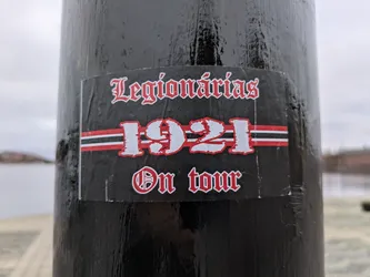 Black and red sticker with the text "Legionárias 1921 On Tour" in a gothic style font. The number 1921 is prominently displayed with red and white stripes beneath it.