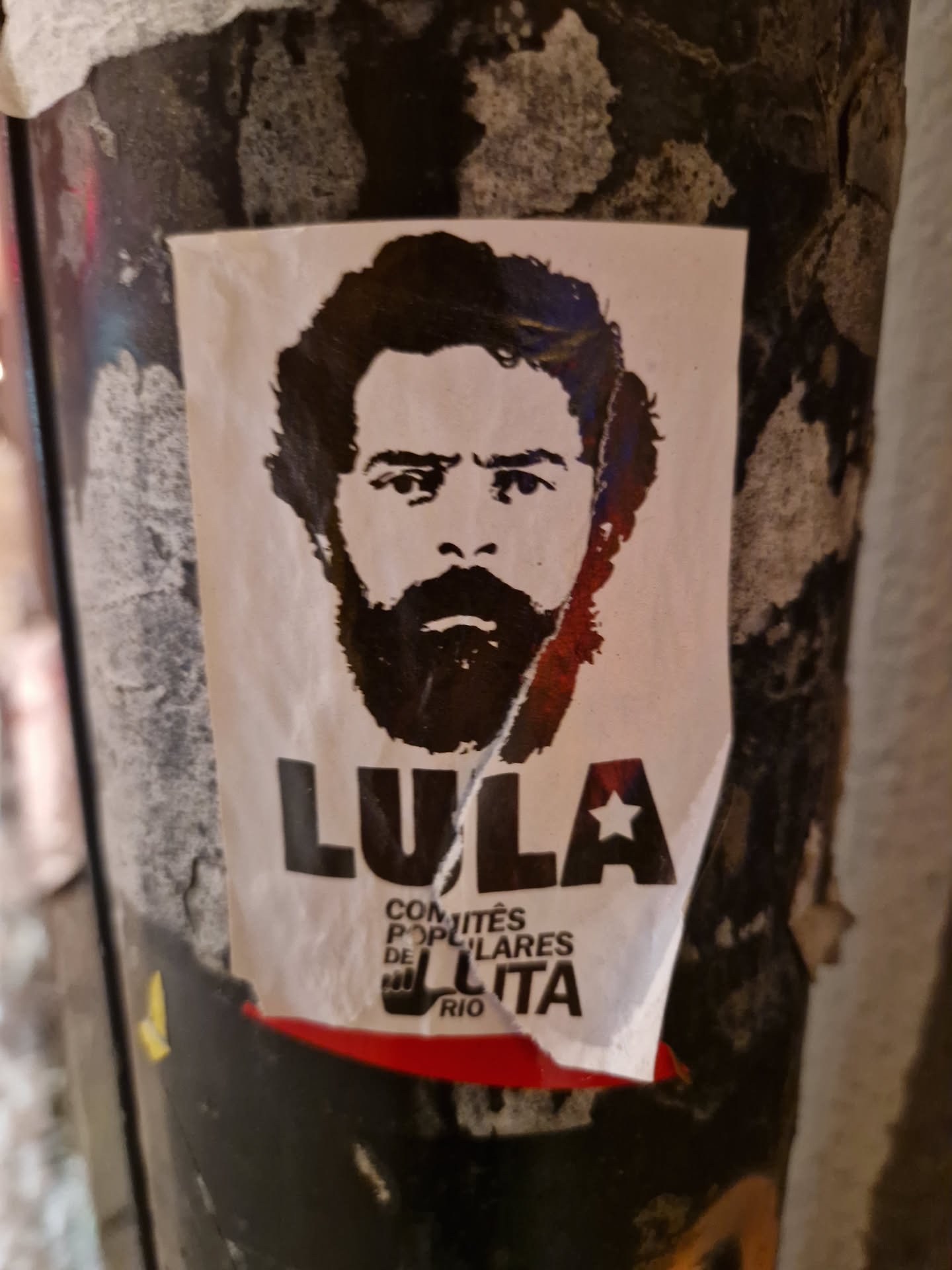 A black and white sticker featuring a portrait of Luiz Inácio Lula da Silva, former president of Brazil. The sticker includes text in Portuguese that translates to "Lula - Popular Committees of Struggle Rio".