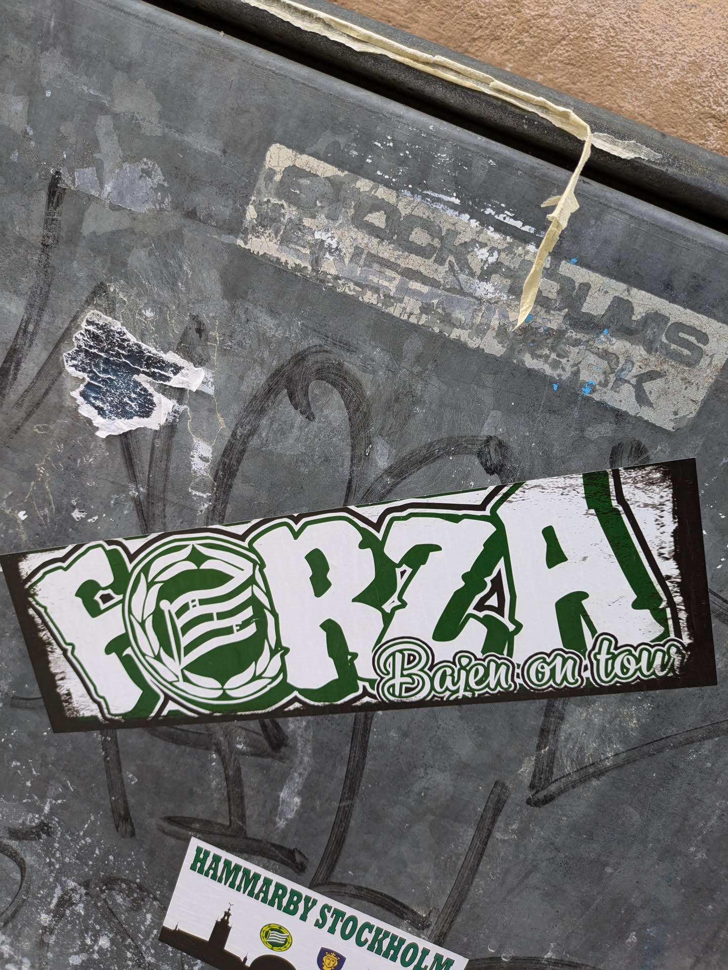 A green and white sticker with the word FORZA in graffiti style and the text Bajen on tour. It features a green emblem with a stylized letter inside.