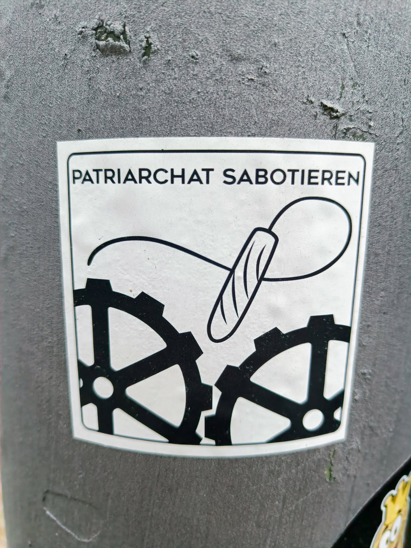 A sticker with a design showing a tampon disrupting gears, accompanied by the text "Patriarchat Sabotiereren" (Sabotage the Patriarchy).