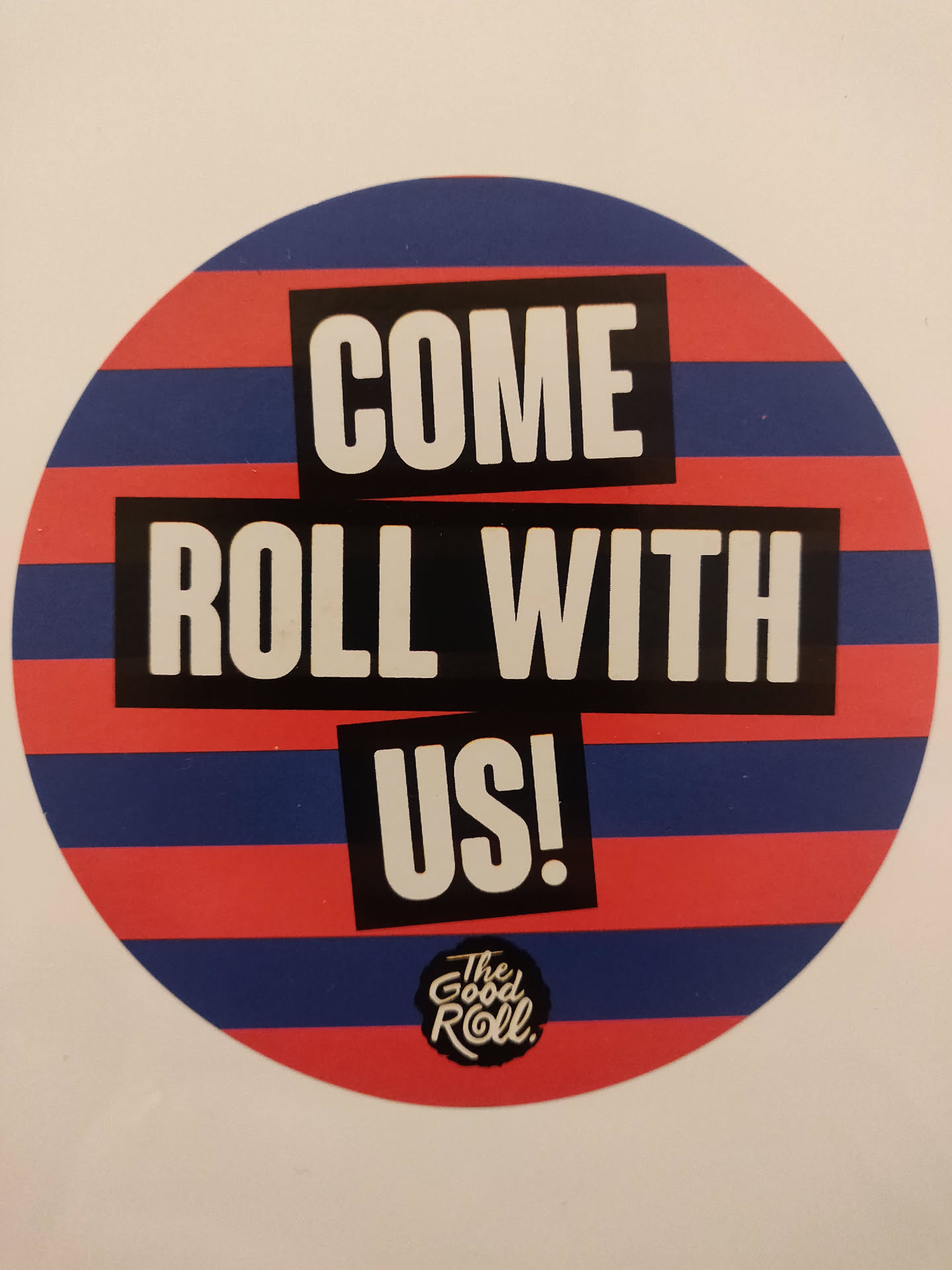 Round sticker with red and blue stripes.  It has the text 'COME ROLL WITH US!' in a bold, sans-serif font. A smaller logo is at the bottom that says 'The Good Roll'.