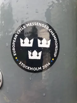 A black circular sticker with three crowns and the text "European Cycle Messenger Championship" and "Stockholm 2014".