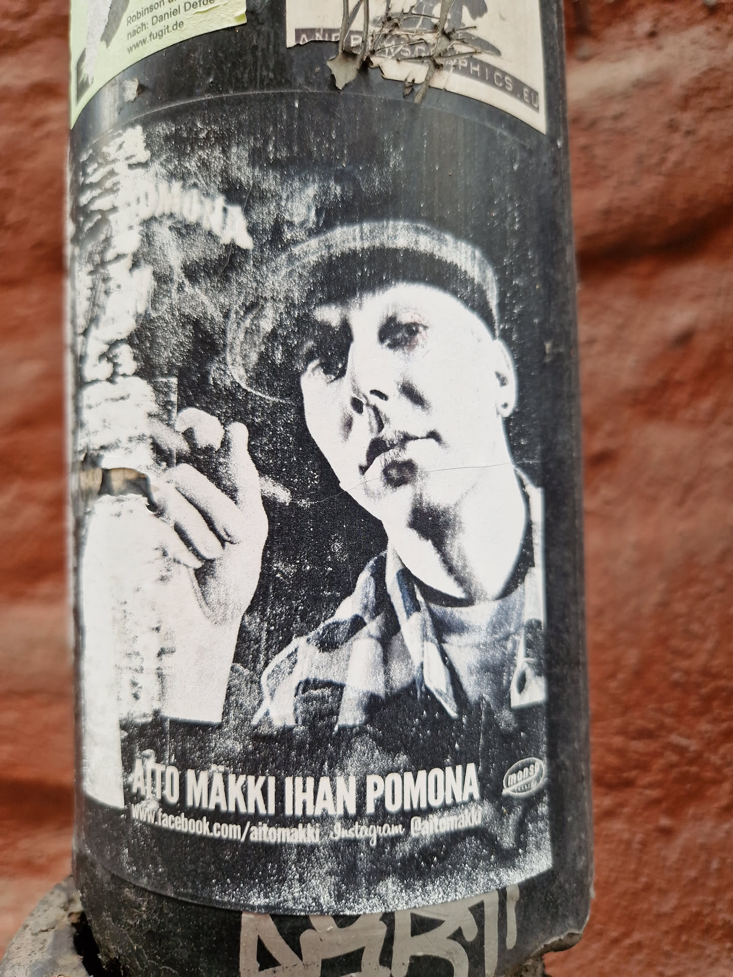 Black and white sticker featuring a portrait of a person smoking a cigar. The sticker includes the artist's name and social media links.