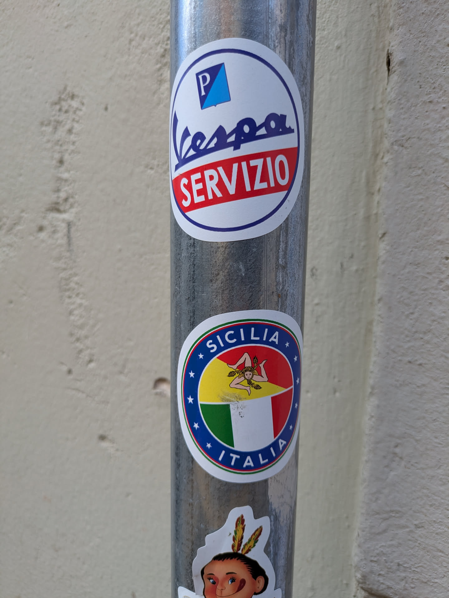 A round sticker features the flag of Sicily, Italy, with a Trinacria symbol in the center. The flag is split diagonally into yellow, red, and green sections. The sticker is surrounded by a blue border with white stars and the words "SICILIA" and "ITALIA".