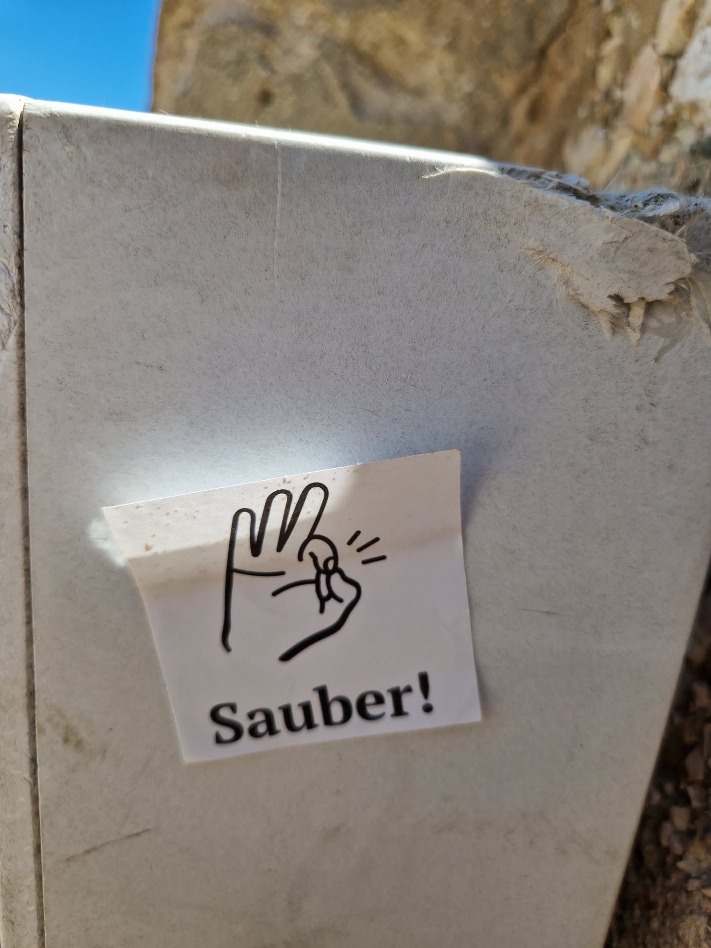 A sticker with a hand gesture and the word "Sauber!" (Clean!) in German.  The hand gesture symbolizes cleanliness or approval.