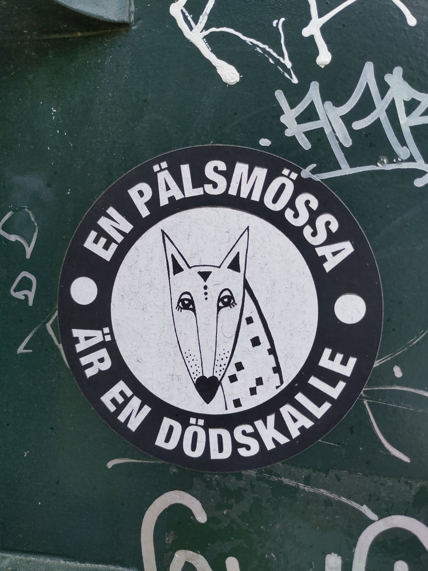 A round black and white sticker with a stylized fox and text in Swedish.  The text translates to "A fur hat is a skull."