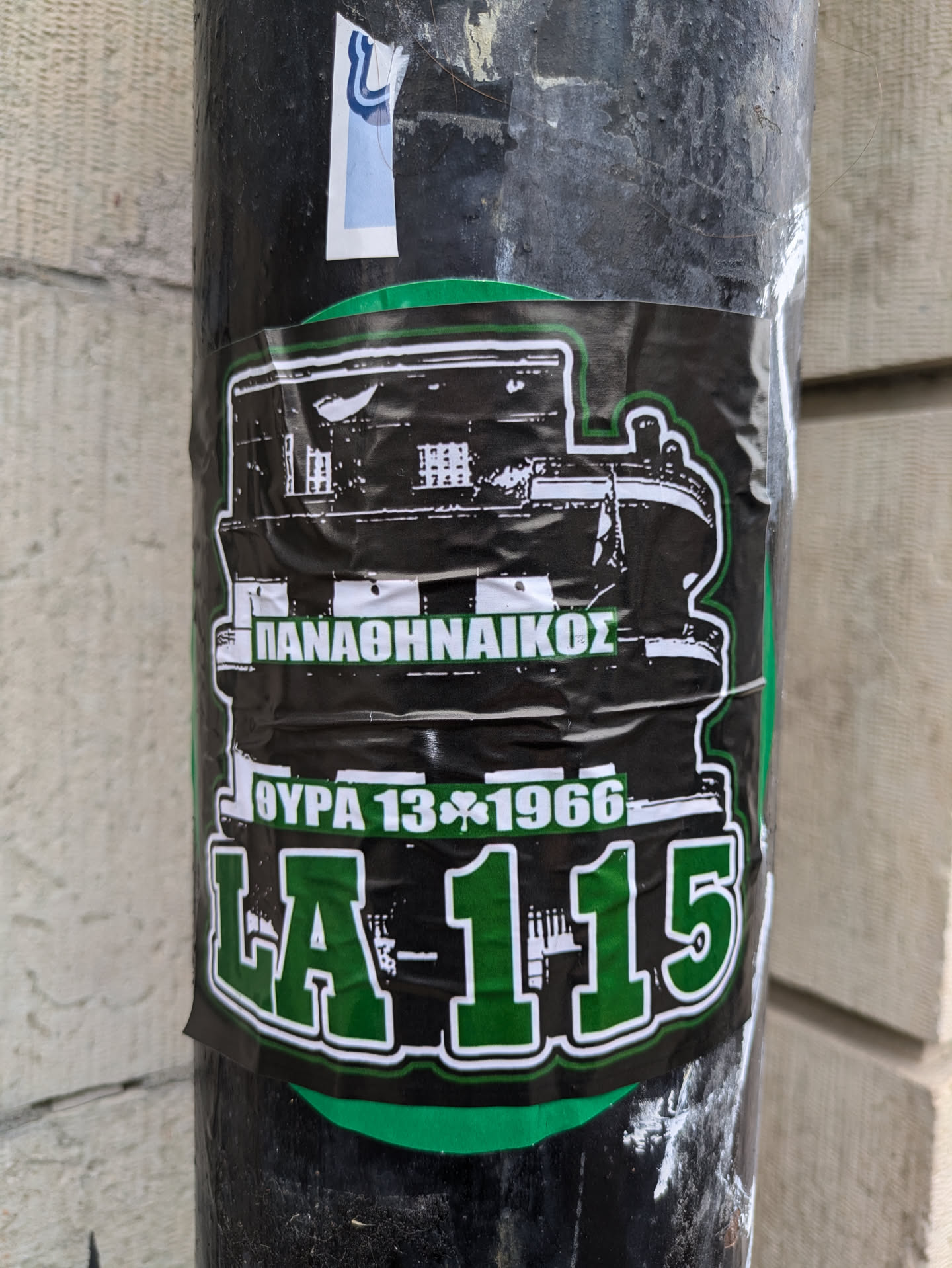A black and green sticker commemorating Panathinaikos's victory in the 1966 European Cup Winners' Cup final. The sticker features a drawing of the stadium and the score of the final match, 1-0 against West Ham United. The text "ΠΑΟ" is visible, which is an abbreviation for Panathinaikos.
