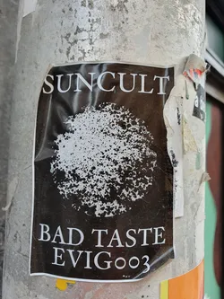 Black and white sticker with a circular design and the text 'SUNCULT', 'BAD TASTE', and 'EVIG003'.
