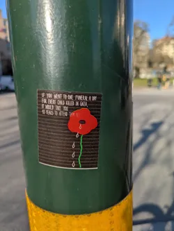 The sticker features a red poppy with teardrops beneath it, symbolizing mourning, with the text 'IF YOU WENT TO ONE FUNERAL A DAY FOR EVERY CHILD KILLED IN GAZA, IT WOULD TAKE YOU 13 YEARS TO ATTEND THEM ALL.'