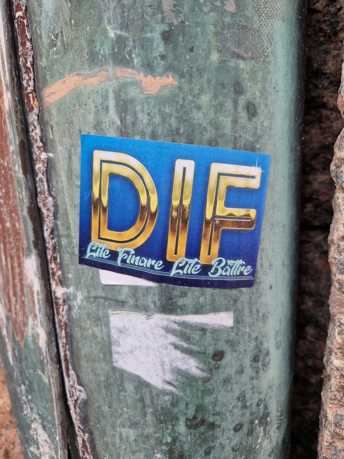 A blue sticker with gold lettering that says DIF. Below the main text it says Lite Fimare Lite Battre in a stylized font.