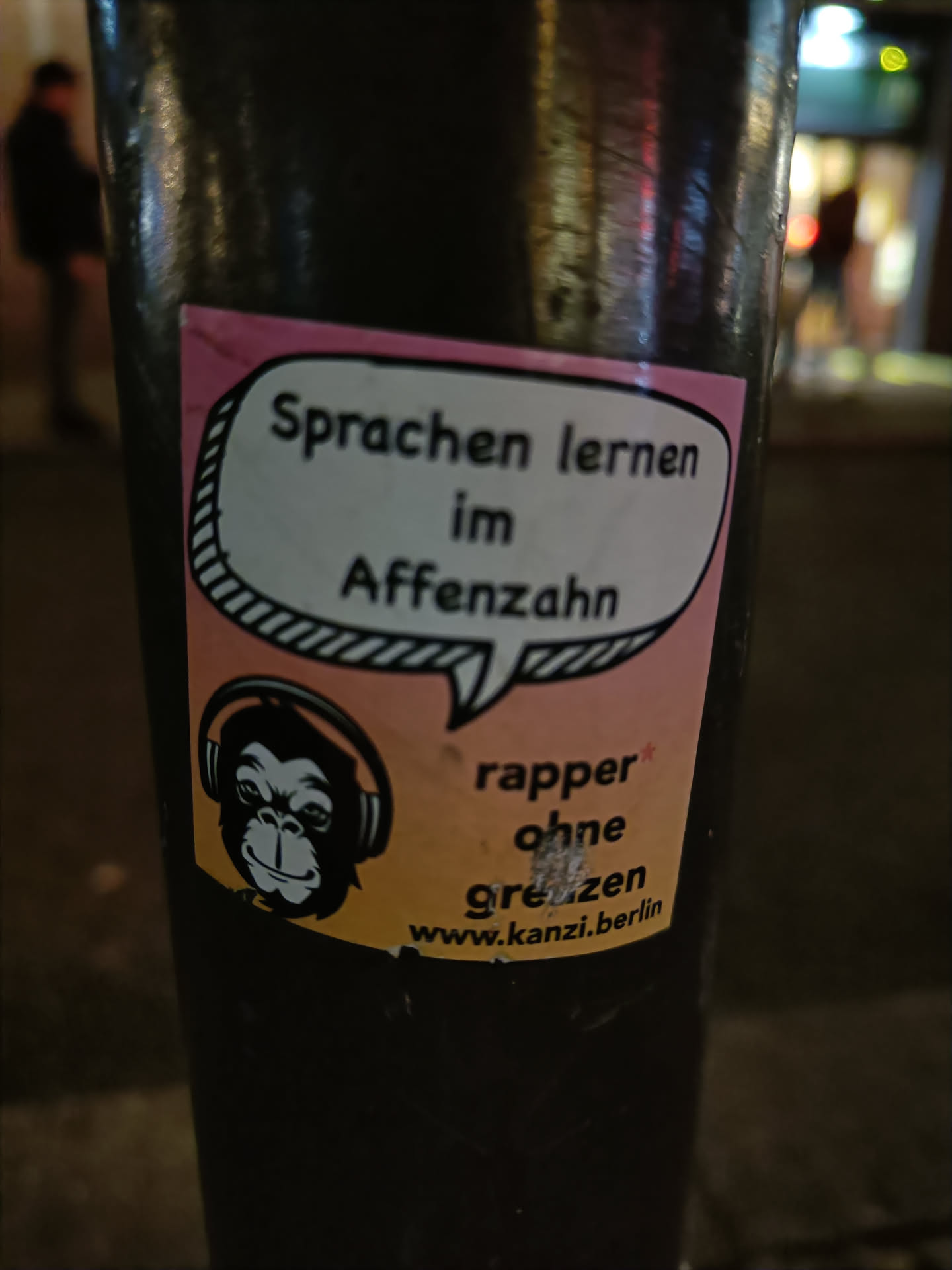 A sticker featuring a monkey wearing headphones and text that says "Sprachen lernen im Affenzahn" (Learn languages quickly) and "rapper ohne grenzen" (rapper without borders).  A website address is also included.