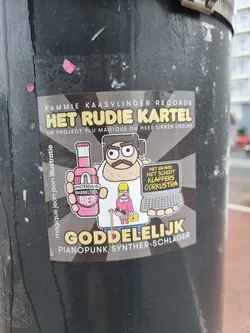 Sticker featuring cartoon artwork of a man holding a beer bottle and a laptop with text overlay.  The sticker is from Kammie Kaasvlinder Records and is described as a PianoPunk Synth-Schlager project.