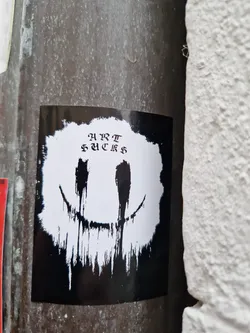 Black and white sticker with a dripping smiley face and the words "HURT FEELINGS" written in a stylized font. The style is reminiscent of grunge or dark art.