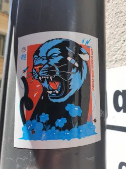 A sticker featuring a stylized illustration of a panther with its mouth open, surrounded by blue flowers and small bees. The art style is bold and graphic with a color palette of black, blue, red, and white. The artist's website is printed on the sticker.
