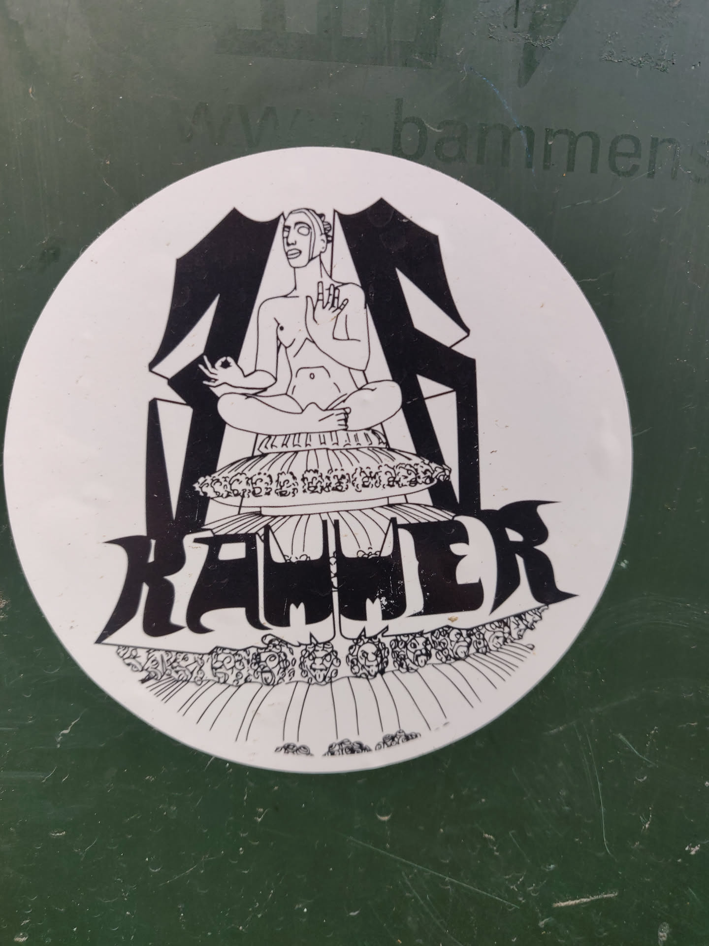 This round sticker showcases a striking black and white illustration. A figure sits cross-legged on a platform, possibly a throne or altar, surrounded by intricate detailing and what looks like a symbolic border. The word "RAWLER" is prominently displayed in stylized lettering below the figure, adding to the mysterious and artistic appeal of this sticker.