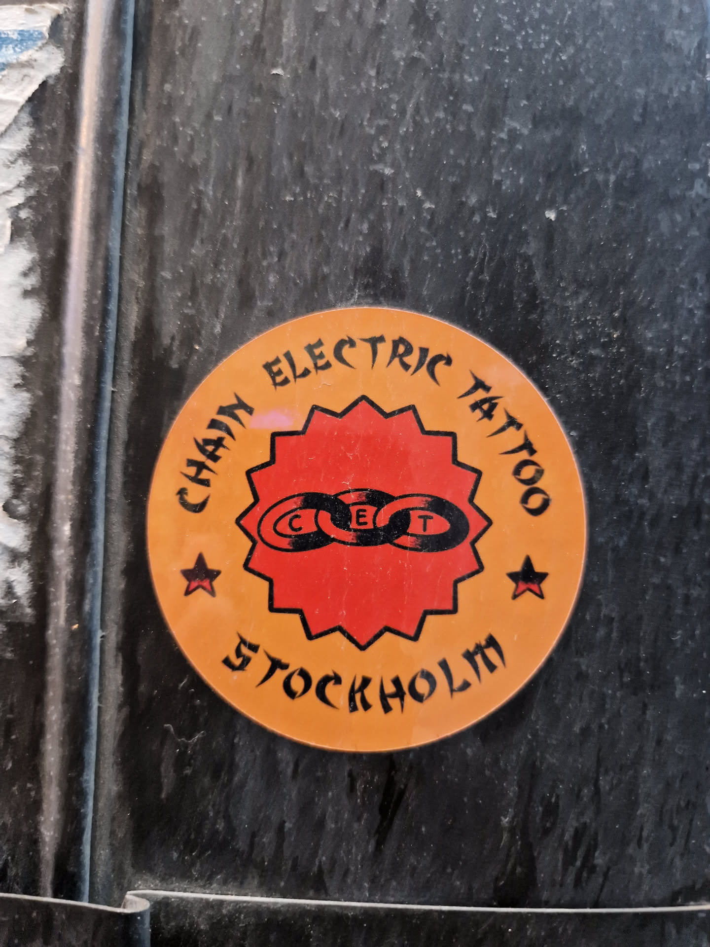 Round sticker with the text "Chain Electric Tattoo" and a logo of three linked chains forming a circle. The words "Stockholm" are written under the main text.