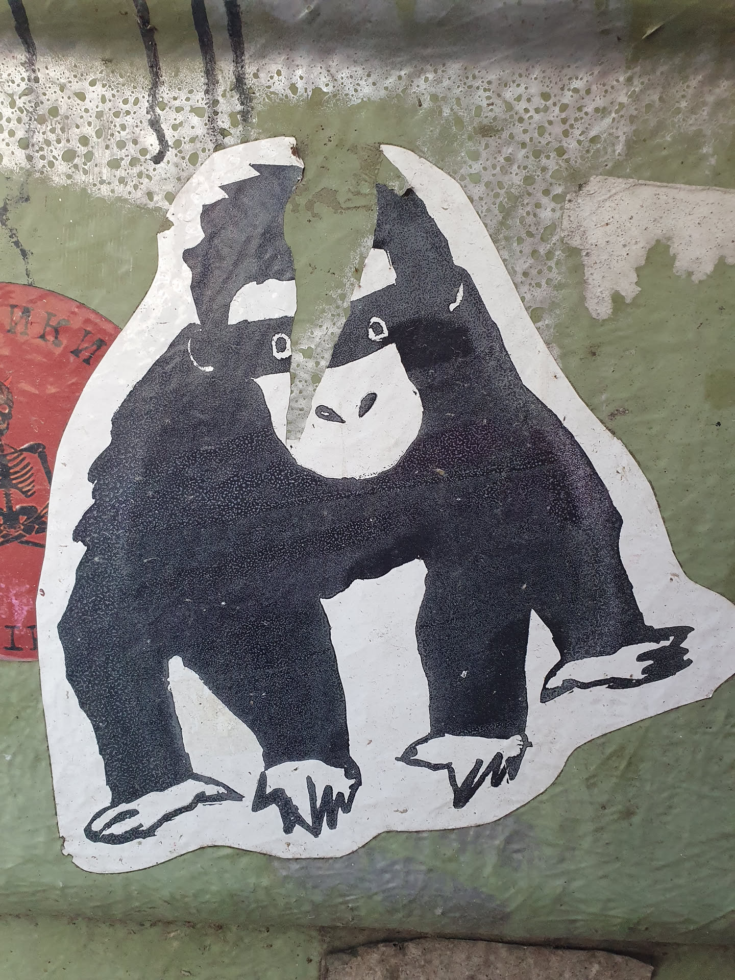 This sticker features a stylized illustration of a monkey wearing a mask, reminiscent of a superhero or secret agent. The design is simple yet striking, with bold black outlines and white background. The sticker appears to be hand-drawn and is slightly damaged around the edges, adding to its unique character.