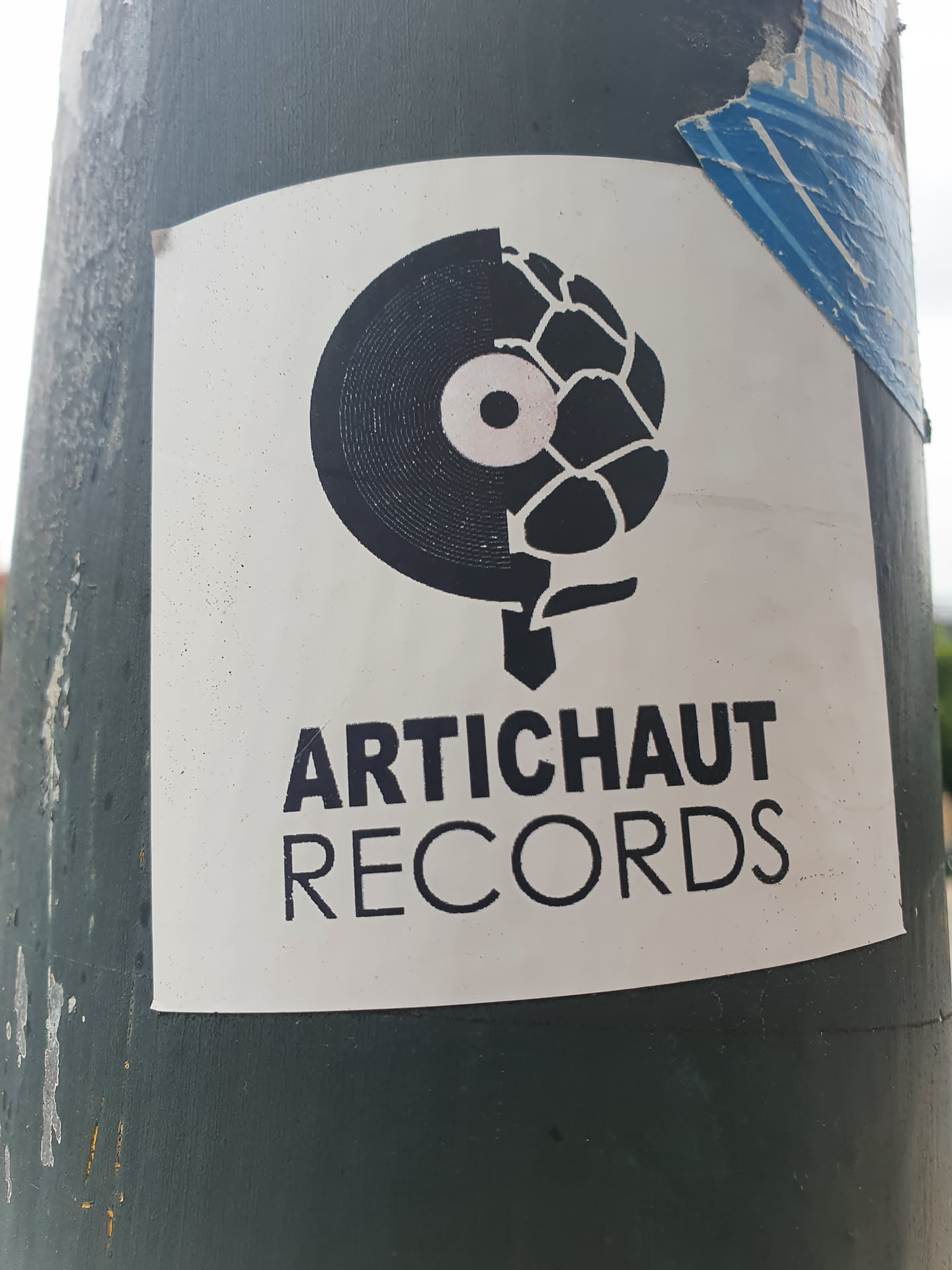A white sticker featuring a black and white design.  Half of the design is a vinyl record and the other half is an artichoke. Below the design, the text 'ARTICHAUT RECORDS' is written in a sans-serif font. 