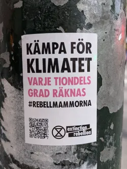 A sticker advocating for climate action with a QR code and Extinction Rebellion logo. The text is in Swedish.