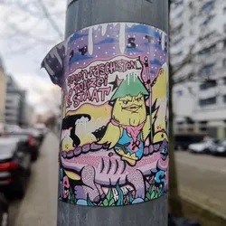 A colorful sticker featuring a cartoon illustration of a yellow bird-like character with a green hat riding on the back of a pink dinosaur. The background is a mix of yellow, purple, and pink hues, with snow-like elements at the top. German text reading "Gegen Faschisten, Polizei & Staat" which translates to "Against Fascists, Police & State" is prominently displayed on the sticker.