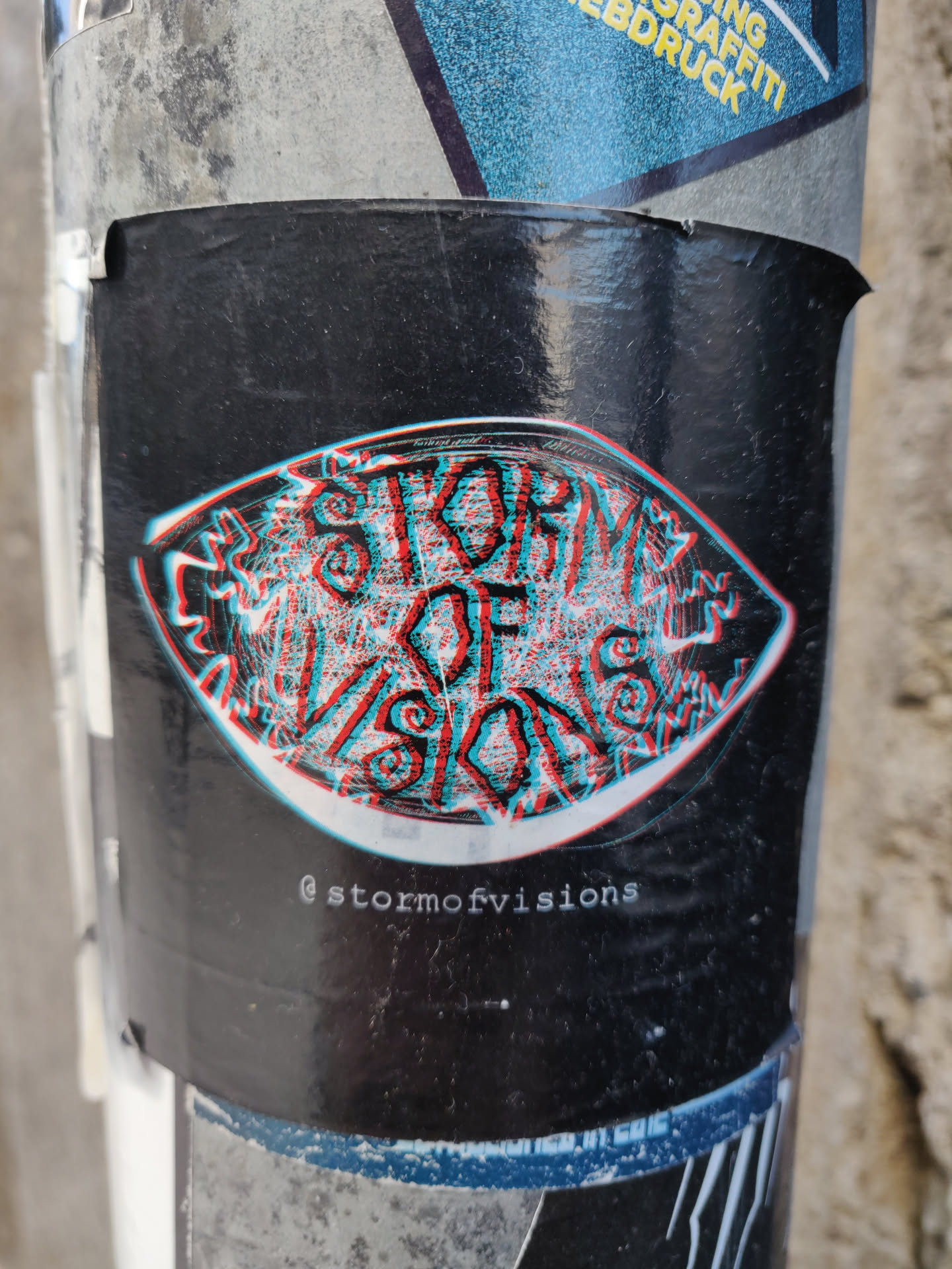 A black and white sticker with a trippy eye design. The words "Storm of Visions" are written in the center. The sticker has a glitch effect. The Instagram handle @stormofvisions is written at the bottom of the sticker.
