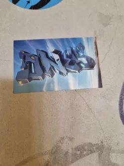 A sticker featuring a stylized illustration of a futuristic city or building, rendered in shades of gray and blue against a light blue sky. The design is abstract but suggests towering structures with technological details.