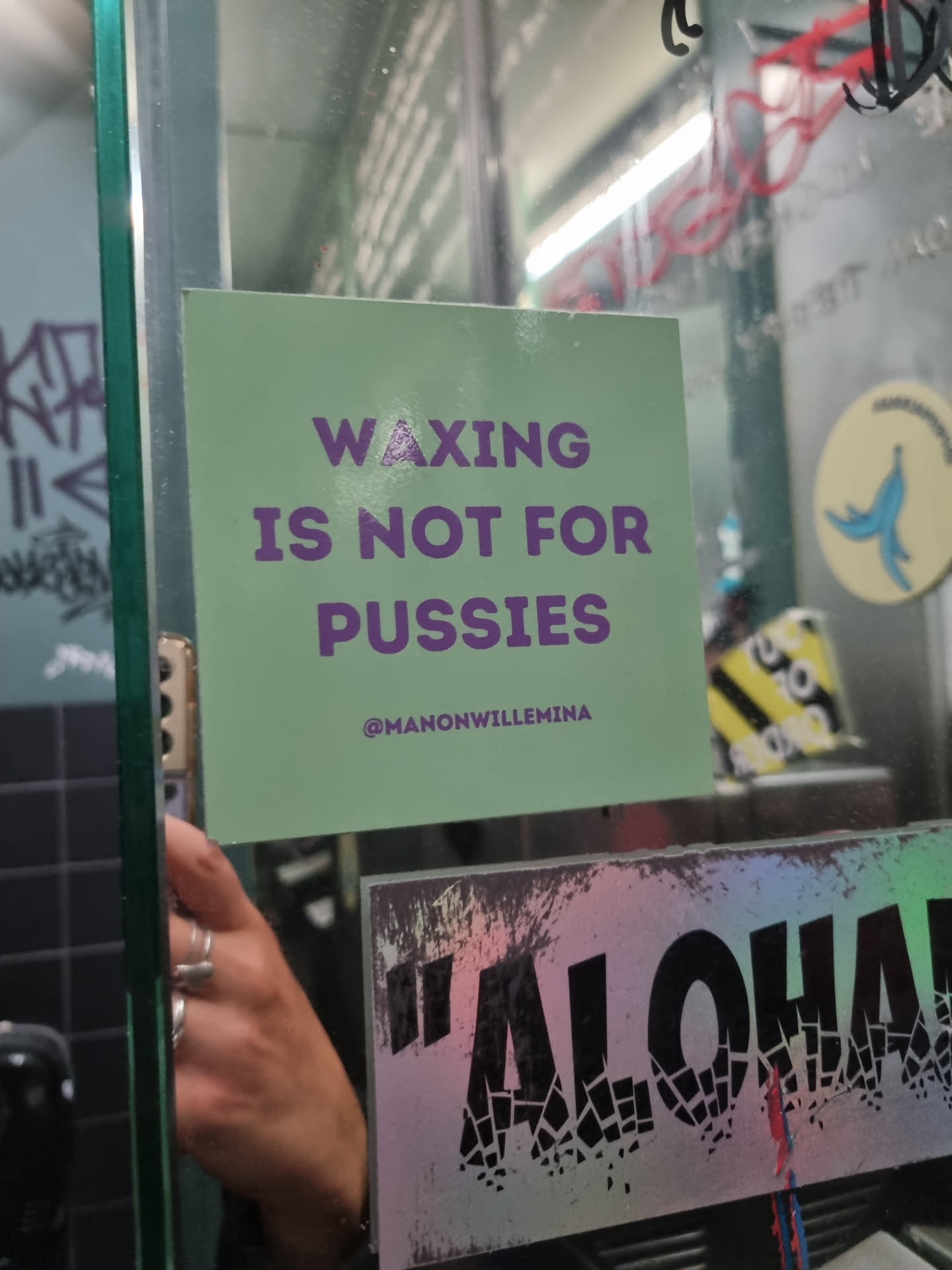 A light green square sticker with a bold message in purple text.  It promotes a defiant attitude towards waxing. The sticker includes an Instagram handle.