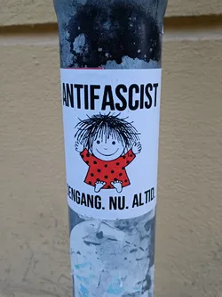 A sticker featuring a cartoon child and the word ANTIFASCIST. Below it says 'ENGANG. NU. ALTID.' which translates from Danish to 'Always. Now. Forever.