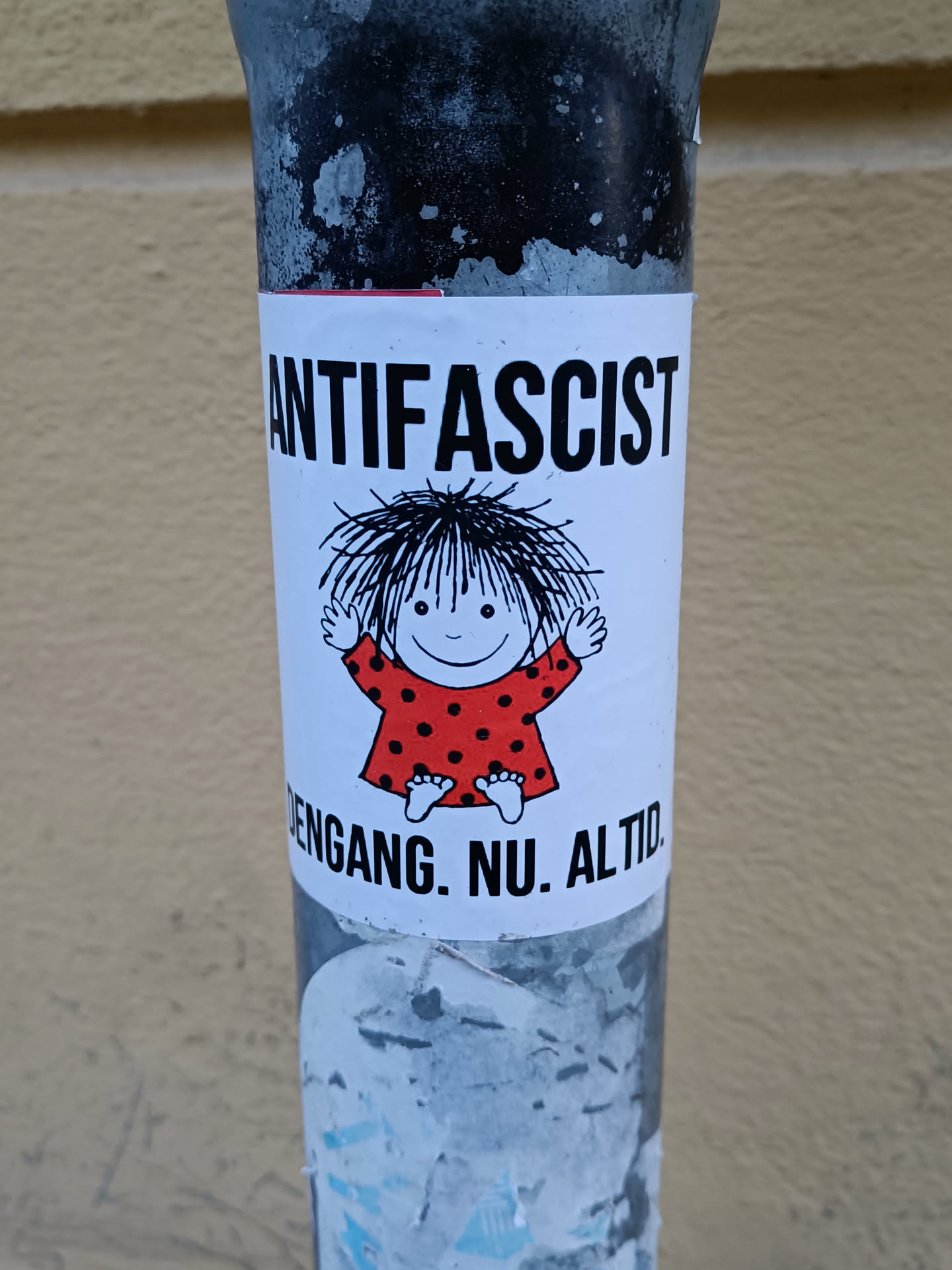 A sticker featuring a cartoon child and the word ANTIFASCIST. Below it says 'ENGANG. NU. ALTID.' which translates from Danish to 'Always. Now. Forever.