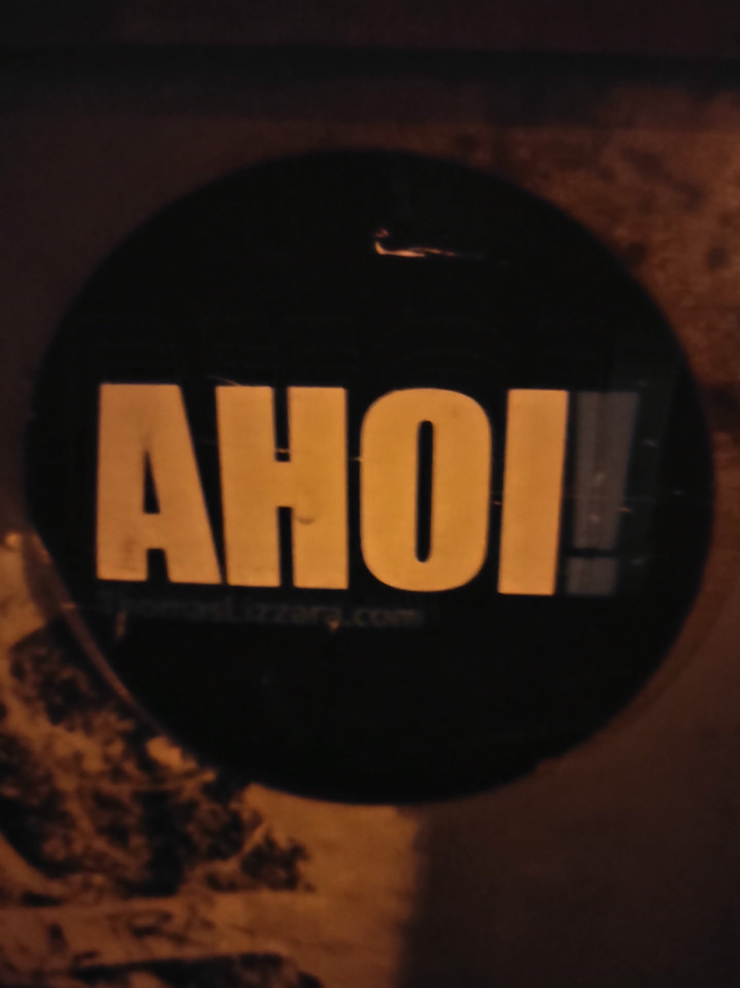 Round black and yellow sticker with the word AHOI! and a website address.