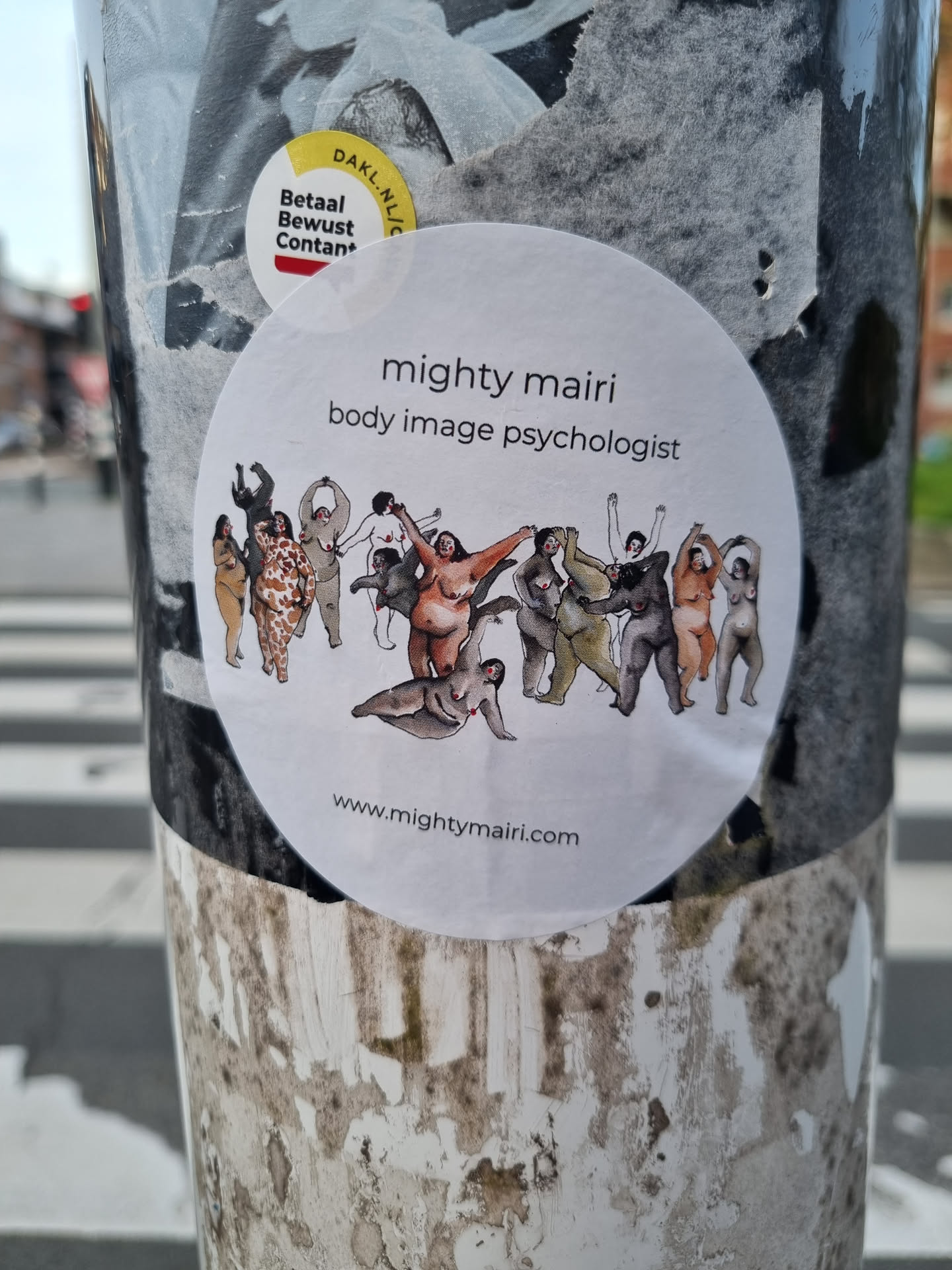 A round sticker featuring an illustration of diverse bodies and the text "mighty mairi body image psychologist" and website address. 