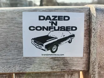 Street sticker A black and white sticker featuring a vintage car illustration and the text 'Dazed 'n Confused'.  The sticker also includes a website address at the bottom.