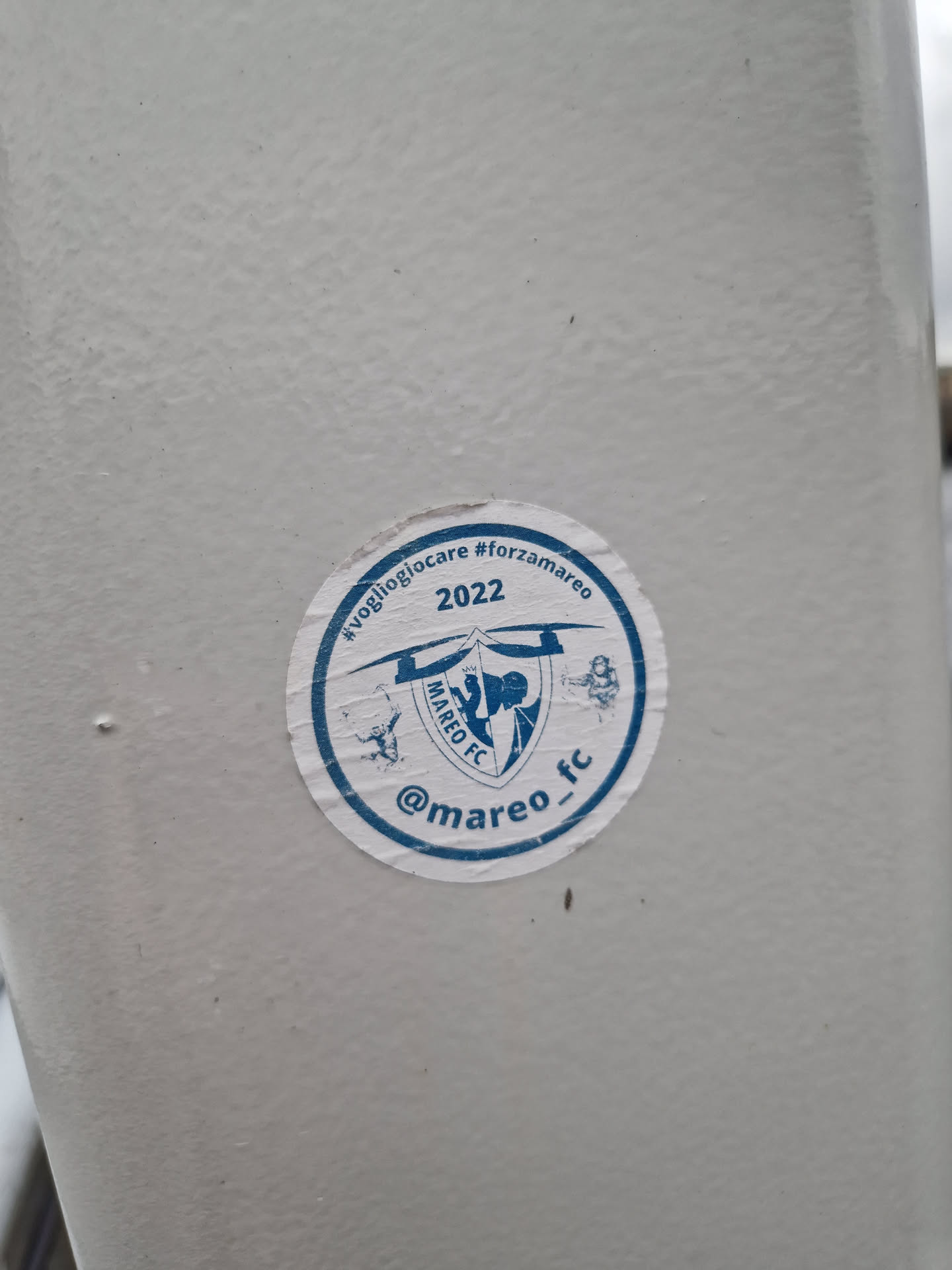 Round sticker featuring Mareo FC logo, text, and hashtags. The sticker is white with blue text and logo.