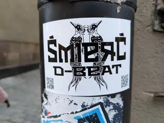 Black and white sticker with two birds and stylized text.  The text 'Smieřc D-BEAT' is prominent.  There are QR codes on either side of the central design.
