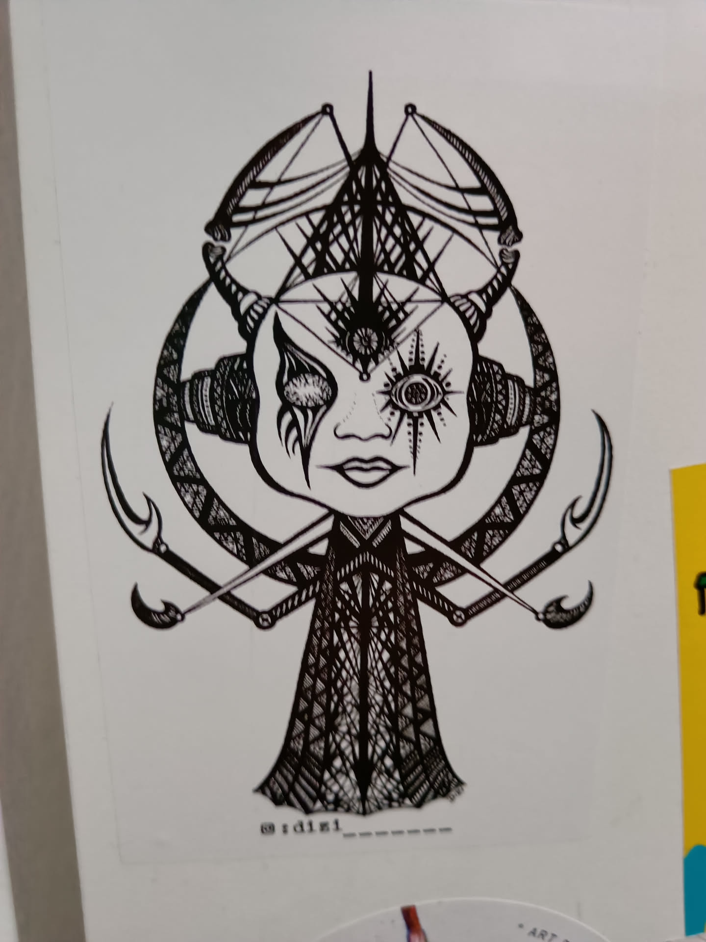 A black and white sticker featuring detailed line art of a creature with horns, intricate patterns, and a third eye. The style is dark and mystical, with a focus on geometric shapes and symbolic imagery. The artist's Instagram handle is visible at the bottom.