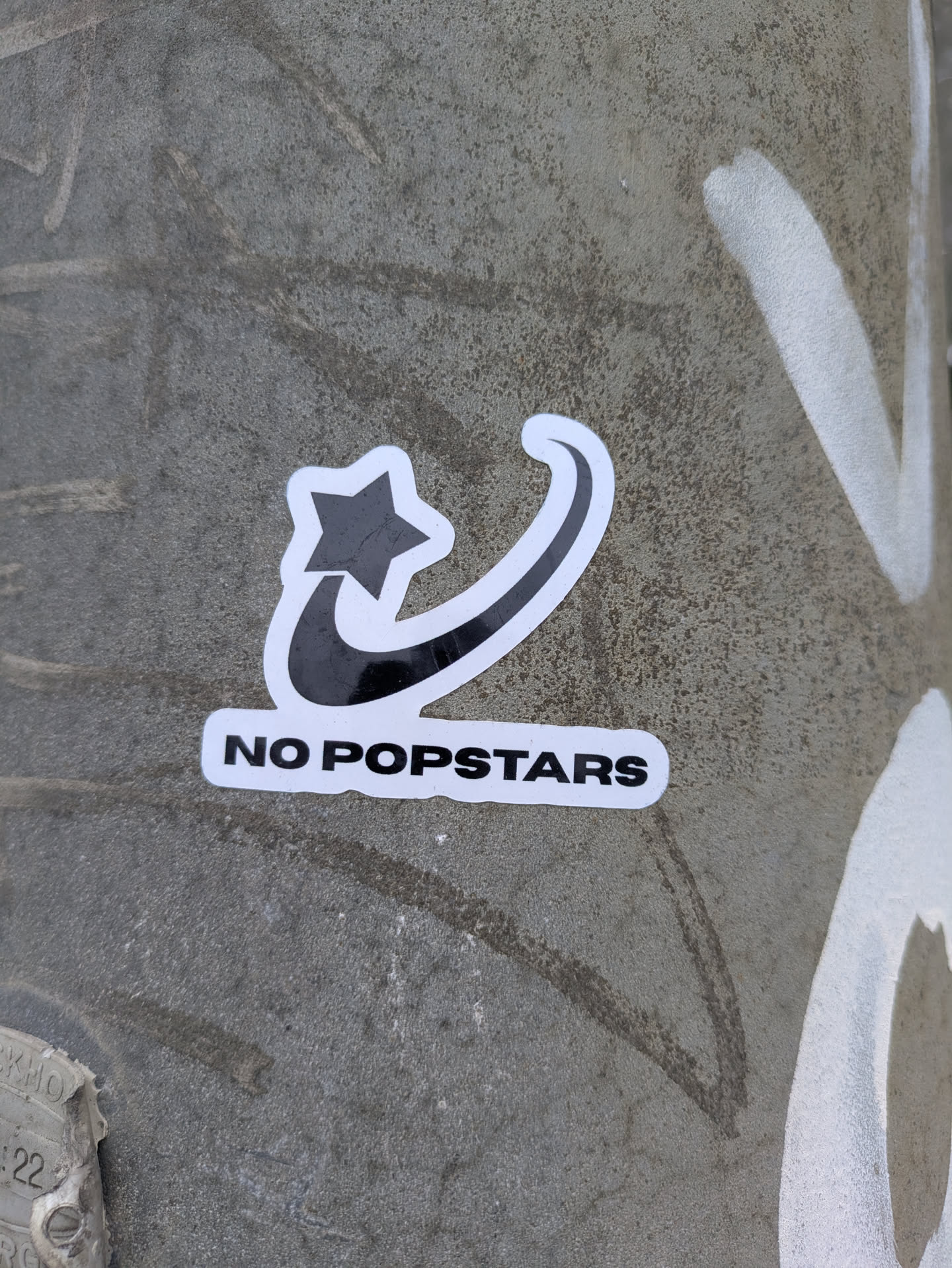 The sticker shows a black star connected to a swoosh-like design. Below the design, the text "NO POPSTARS" is printed in black on a white background.