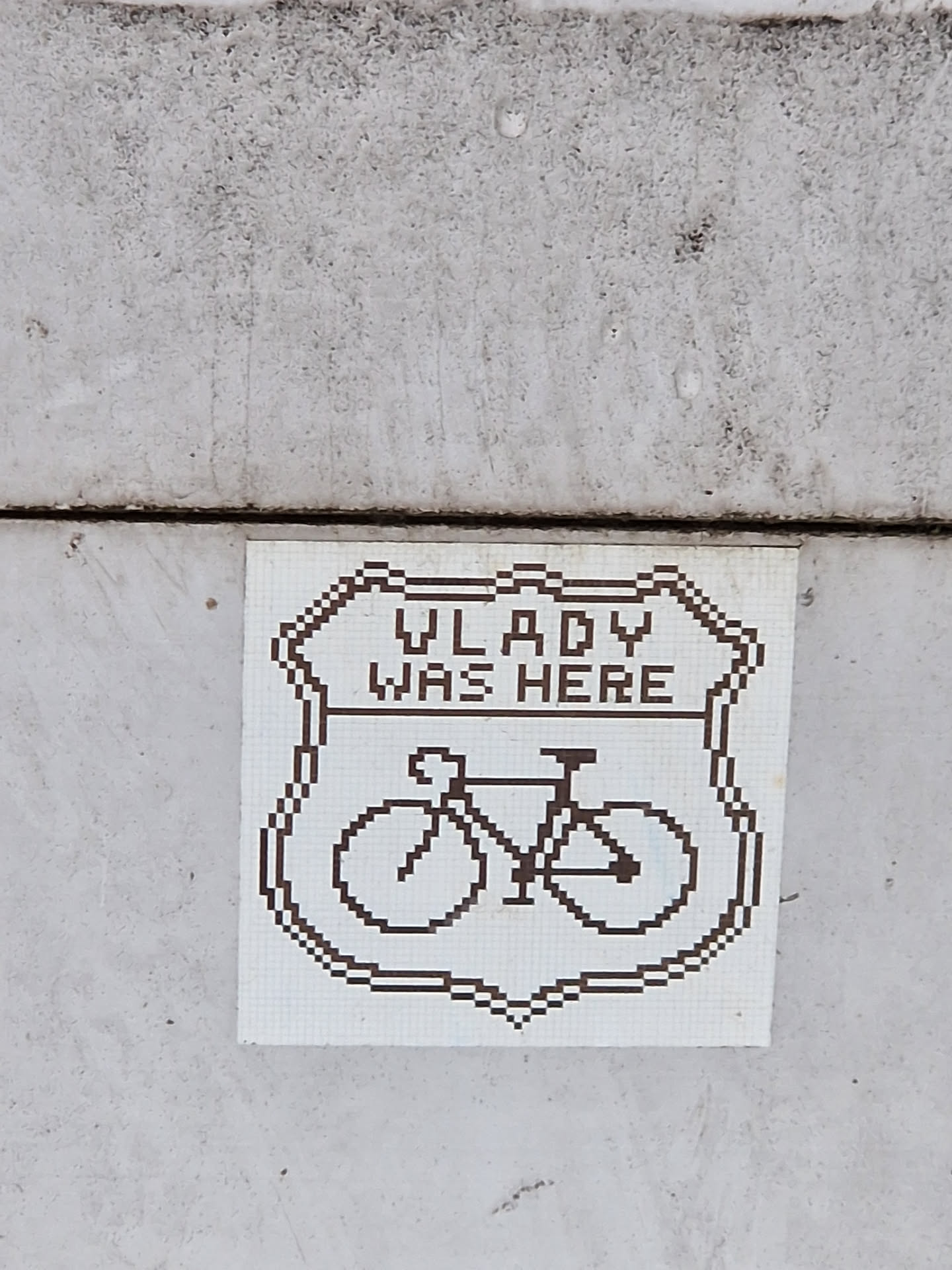 A pixel art sticker depicting a bicycle inside a shield with the text "Vladyslav was here".